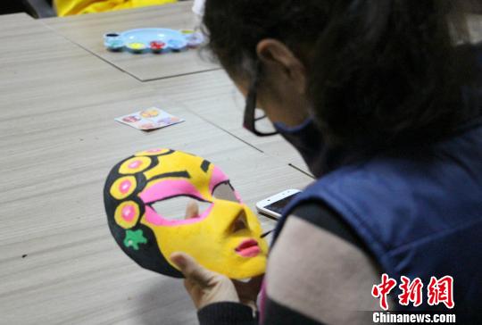 在现场，一女生正在聚精会神地为“青衣”脸谱“化妆”。　赵晓 摄