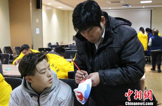 侯志新在现场教授华裔青少年给脸谱上色的技巧。　赵晓 摄