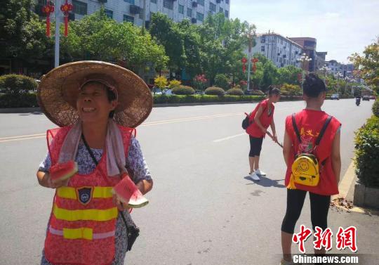 义工为县城环卫工人盛夏送清凉。 米承实 摄 义工为县城环卫工人盛夏送清凉。 米承实 摄