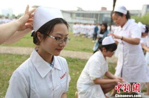 资料图:前辈为医学生戴上护士帽。 泱波 摄 资料图:前辈为医学生戴上护士帽。 泱波 摄