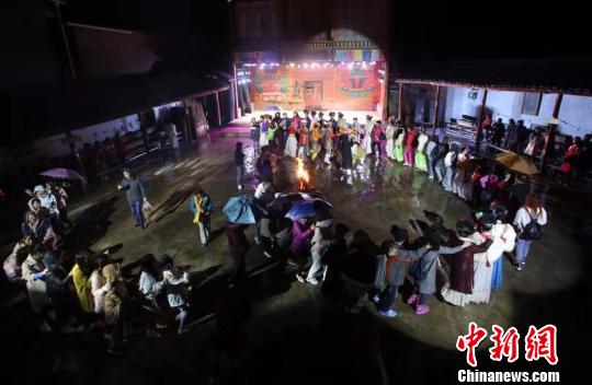 摩梭小伙和摩梭姑娘与游客们手拉着手跳舞。 王磊 摄 摩梭小伙和摩梭姑娘与游客们手拉着手跳舞。 王磊 摄